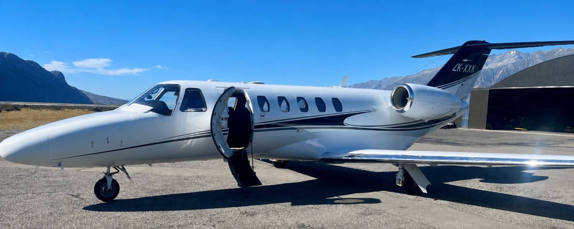 Citation private jet parked beneath the Southern Alps
